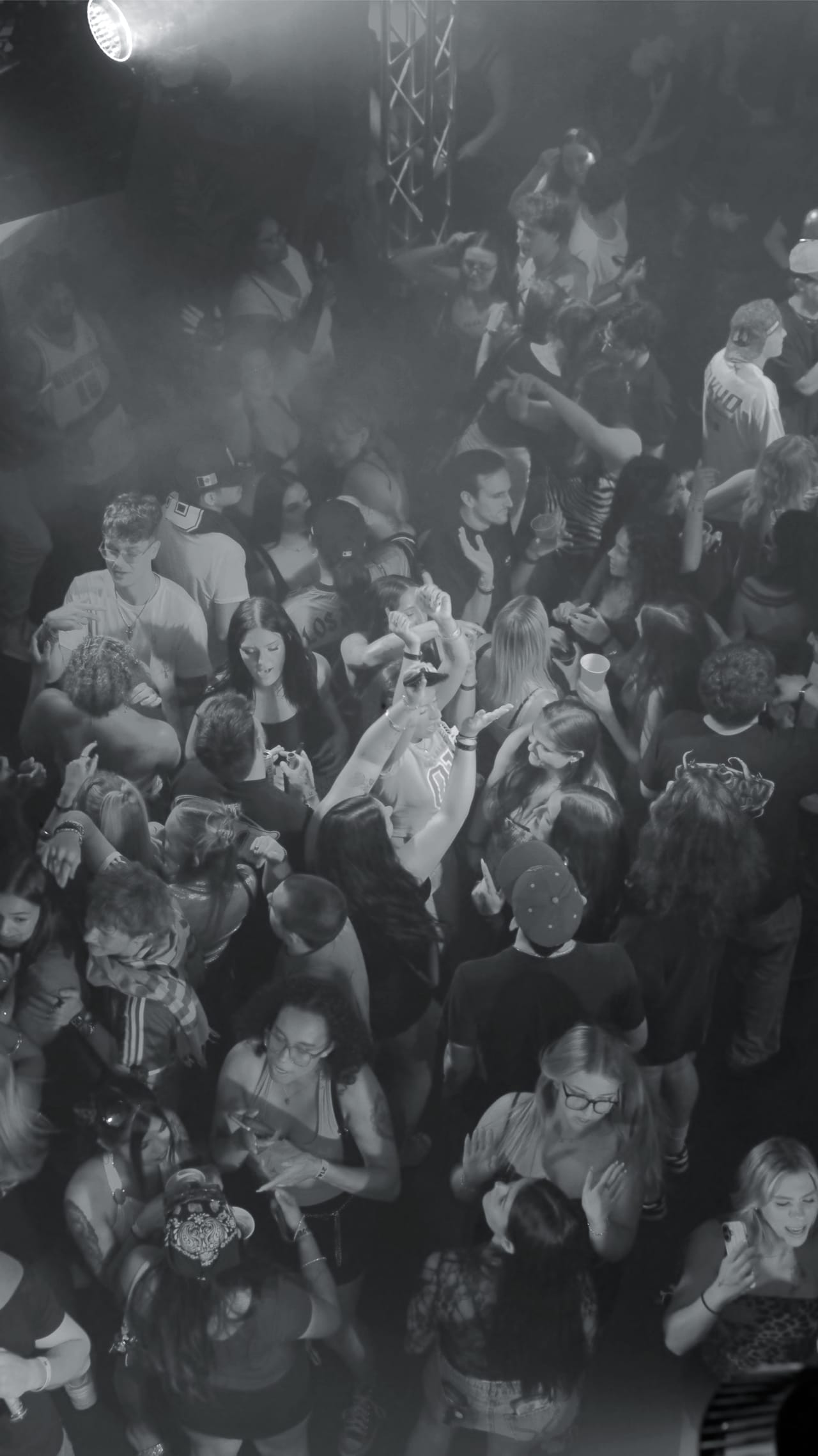 Guests on the floor at CTRL lit by blue and magenta beams from the room's overhead lighting rig.