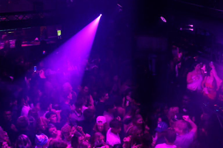 The full room from the balcony with beams over the crowd