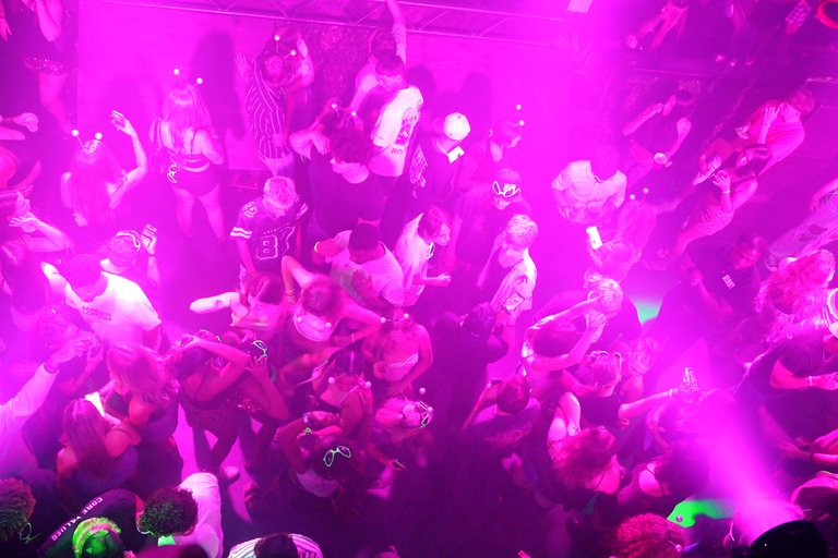 A packed dance floor in pink light at CTRL