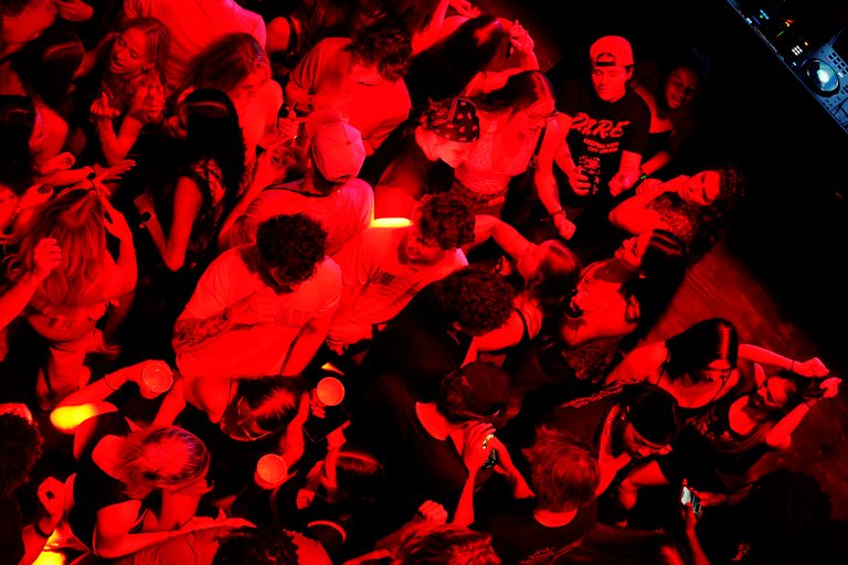 A packed floor in red light, seen from above