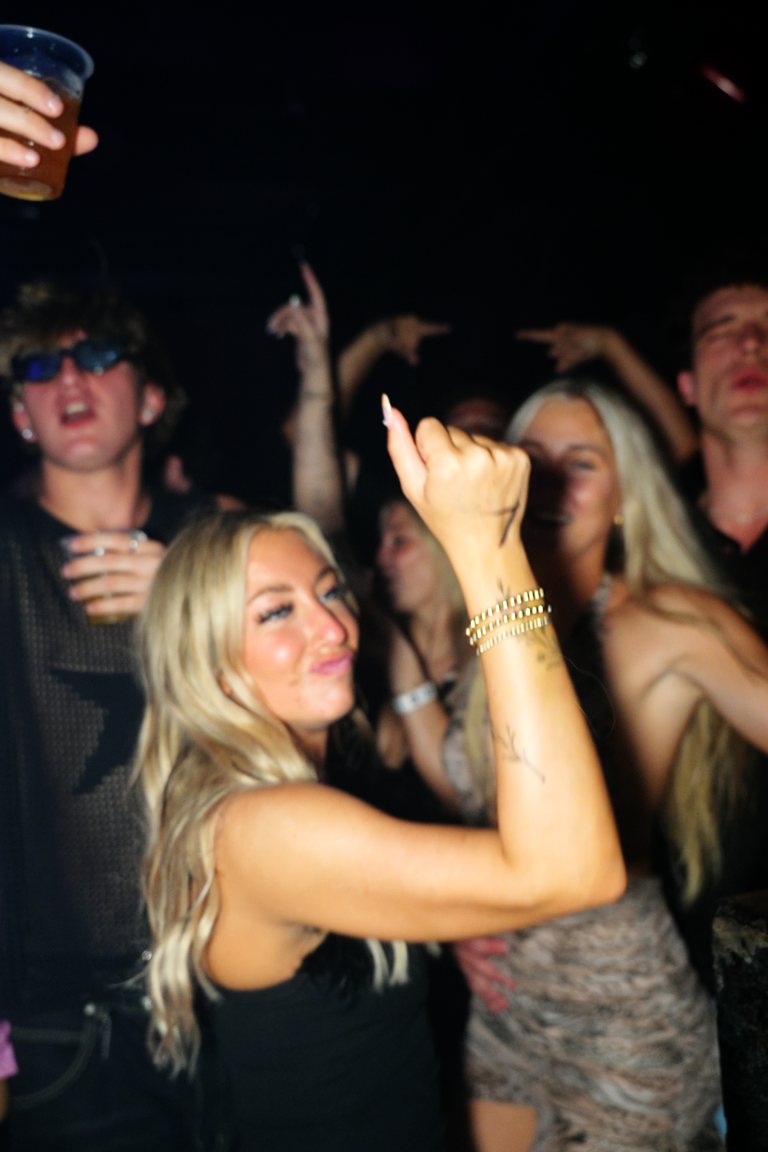 A guest dancing with an arm up in the crowd