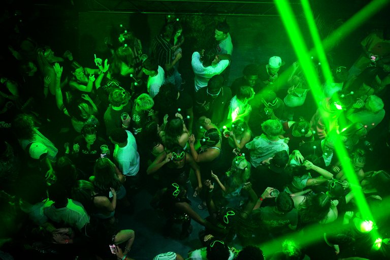 Green lasers over a packed floor, seen from above